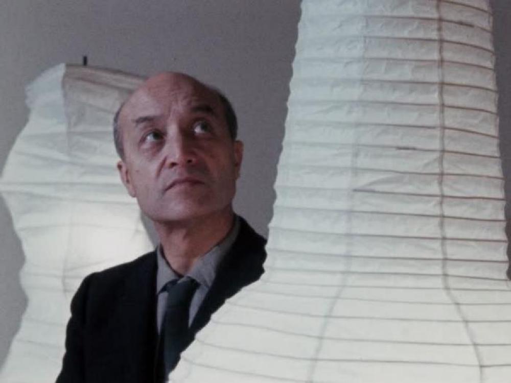 Isamu Noguchi walking through his exhibition "Shapes of Light" at Cordier & Ekstrom Gallery, December 4, 1968–January 4, 1969.