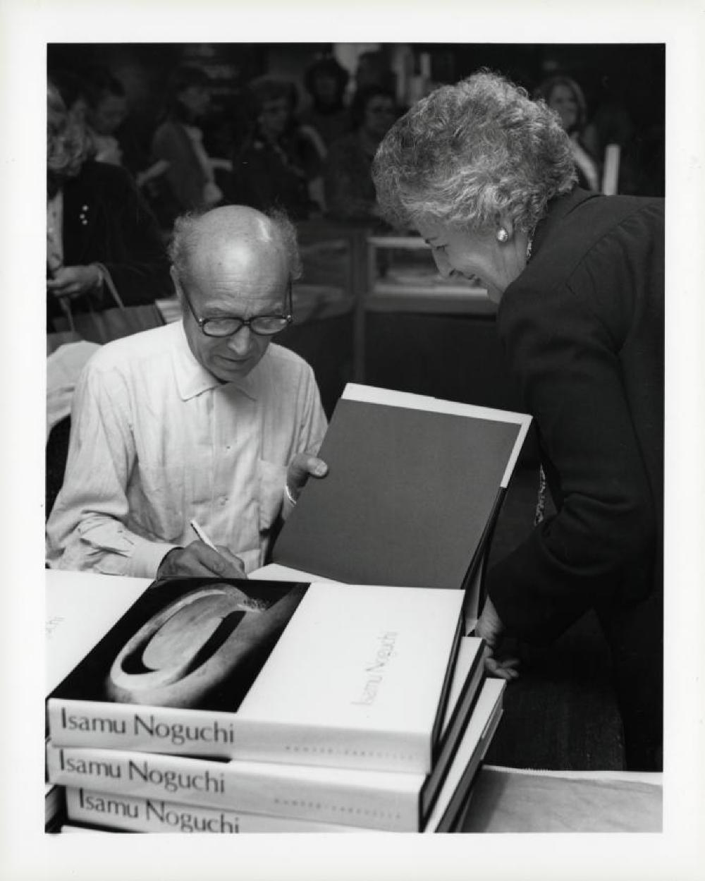 Noguchi signing catalogues at opening reception for "Noguchi's Imaginary Landscapes," Detroit Institute of Fine Arts, April 10 – June 10 1979 (travel from Walker Art Center).