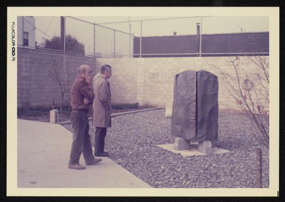 Isamu Noguchi and visitor in the garden at 32-37 Vernon Blvd. in Long Island City prior to the development of the Isamu Noguchi Garden Museum, with End Pieces and Bench